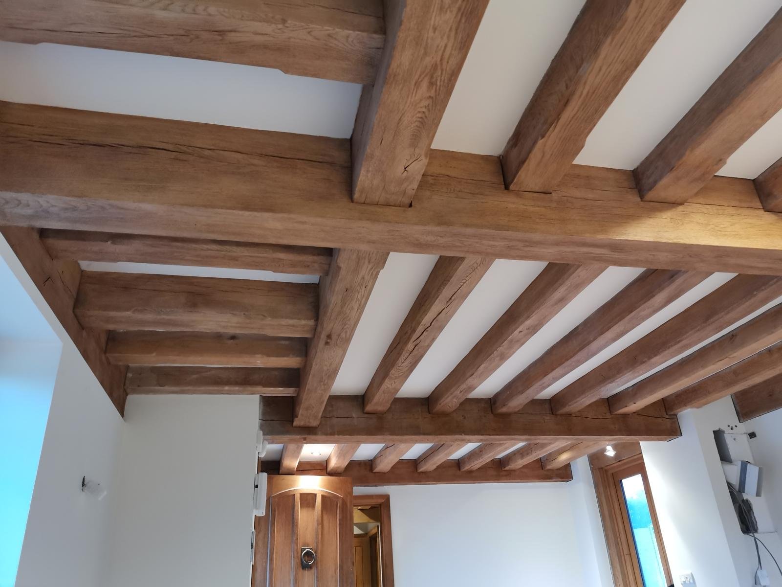 The same beams after restoration, finished in a light oak tone